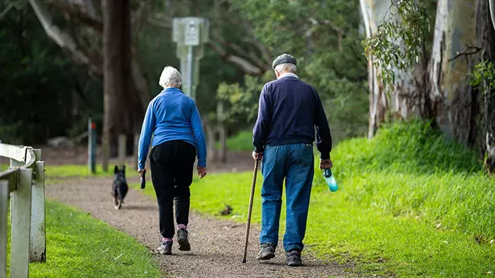Image de deux personnes âgées marchant avec une canne