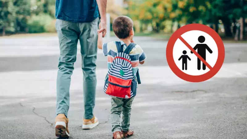 Parent donnant la main à son enfant portant un sac sur le dos avec en haut à droite de l'image un panneau de signalisation enfant et parent barré en rouge