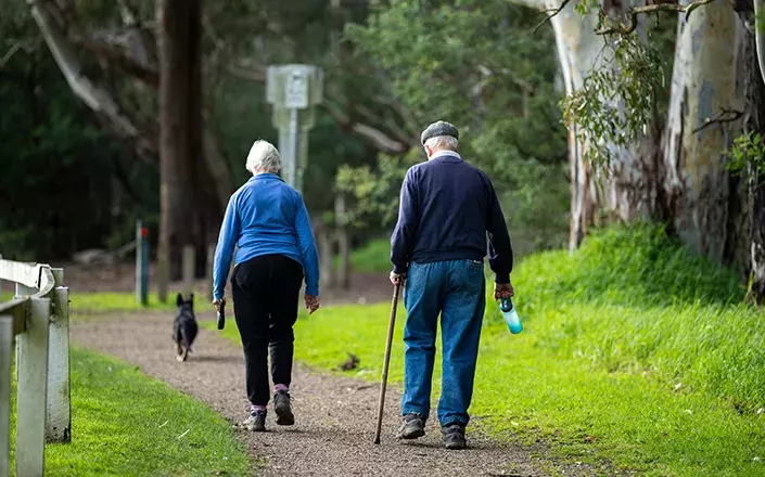 Image de deux personnes âgées marchant avec une canne