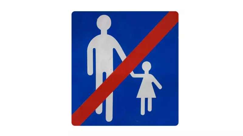 Panneau de signalisation d'un adulte tenant à la main un enfant et qui est barré